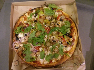 blaze pizza entire pizza with lots of toppings including chicken, tomato, onions